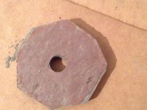 An octagon of slate with a hole in the middle