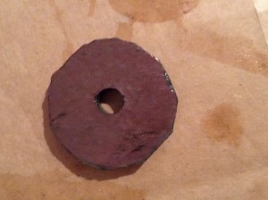 A jagged circle of slate with a hole in the middle