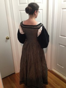 me facing away showing the back of grey dress with gathered skirt and square neck and black velvet sleeves