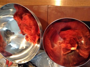 two metal bowls holding red wool