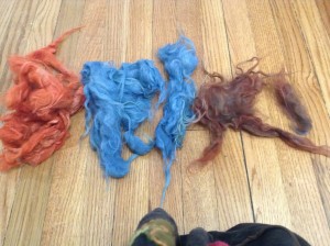 5 piles of wool locks dyed red-orange, blue, and purple/red/brown, I don't know what to call it