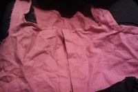 top of a pink dress with the neckline bound in a narrow hem tape and the center front opening bound in a wider hem tape