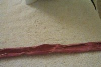 photo of pink linen fabric pinned for ironing into double-fold hem tape