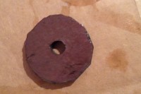 A jagged circle of slate with a hole in the middle