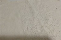 White thread on white linen making large pad stitches